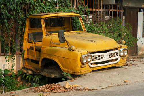 Tailgate of abandoned Vintage yellow truck parked in a field
