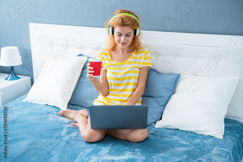 woman blogger smile with coffee in headphones. blogger woman at home. blogger woman work with laptop