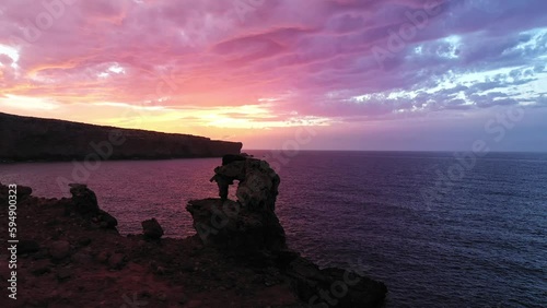 Silhouettes of Cala Morell at sunset along the coastline of Menorca. photo