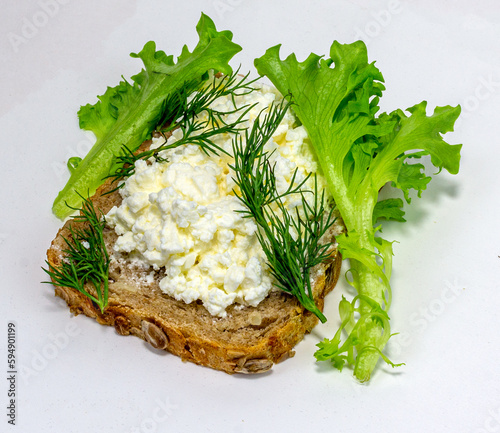 sandwich with soft cheese and herbs on organic bread on a neutral background