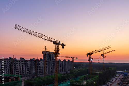 The construction site is in the morning.  In the morning, the tower hangs over the construction site.