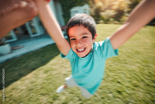 Kid, swing and pov with a boy spinning outdoor in the garden of his home with a parent closeup. Children, portrait and smile with a youth having fun while swinging outside in the yard during summer