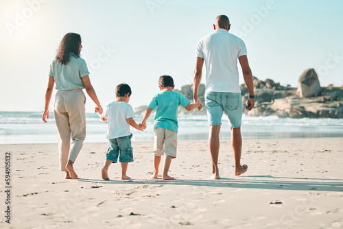 Beach, holding hands and rear view of family walking at the sea, fun and travel on blue sky background. Behind, love and children with parents on an ocean walk, bond and traveling together in Miami