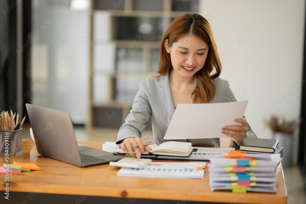 Asian businesswoman holding notebook about business, spending money Asian businesswoman holding notebook about business, spending money