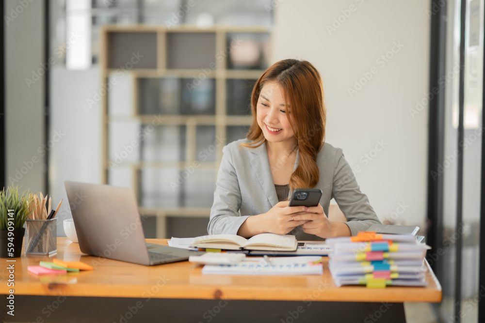 Asian businesswoman holding notebook about business, spending money Asian businesswoman holding notebook about business, spending money