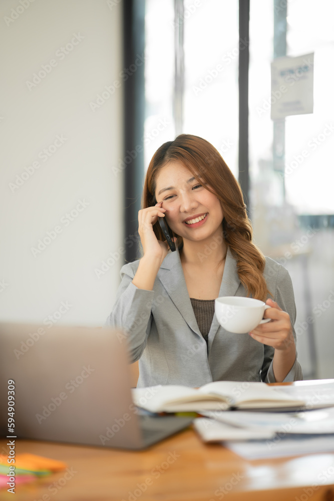 Asian businesswoman holding notebook about business, spending money Asian businesswoman holding notebook about business, spending money