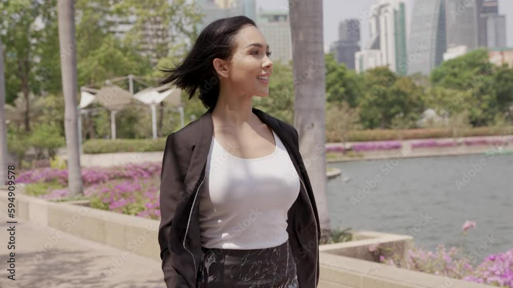 Front view of business happy young woman walking and on urban city park Front view of business happy young woman walking and on urban city park