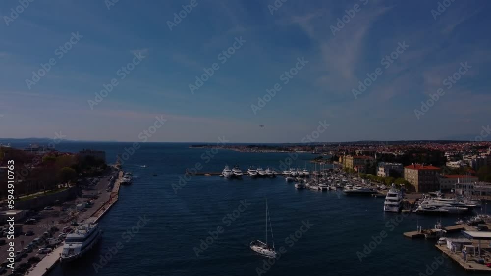 4K aerial tracking shot of the harbour area of Zadar. A yacht sails towards the camera. 4K aerial tracking shot of the harbour area of Zadar. A yacht sails towards the camera.