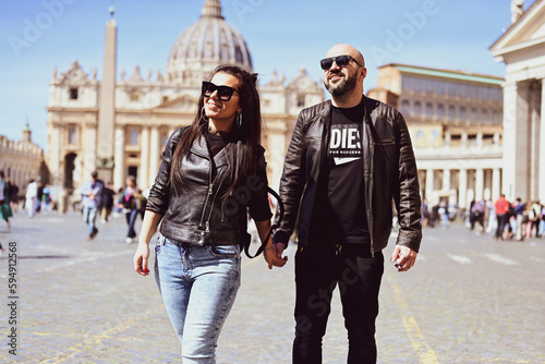 Happy smiling beautiful Tourists couple traveling at Rome, Italy, poses and making photos in front of Vatican City at, Rome, Italy.Concept of Italian gastronomy and travel. Italian couple having