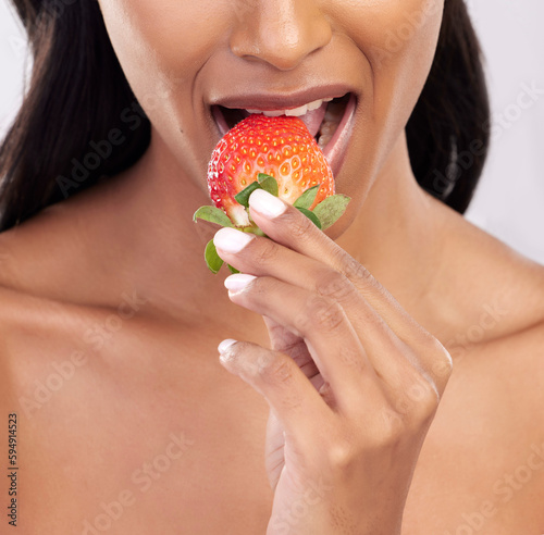 Woman  diet and studio with strawberry  mouth and eating for wellness with beauty  vegan snack and health. Model  food and nutrition with biting fruit  cosmetic and seductive closeup on background