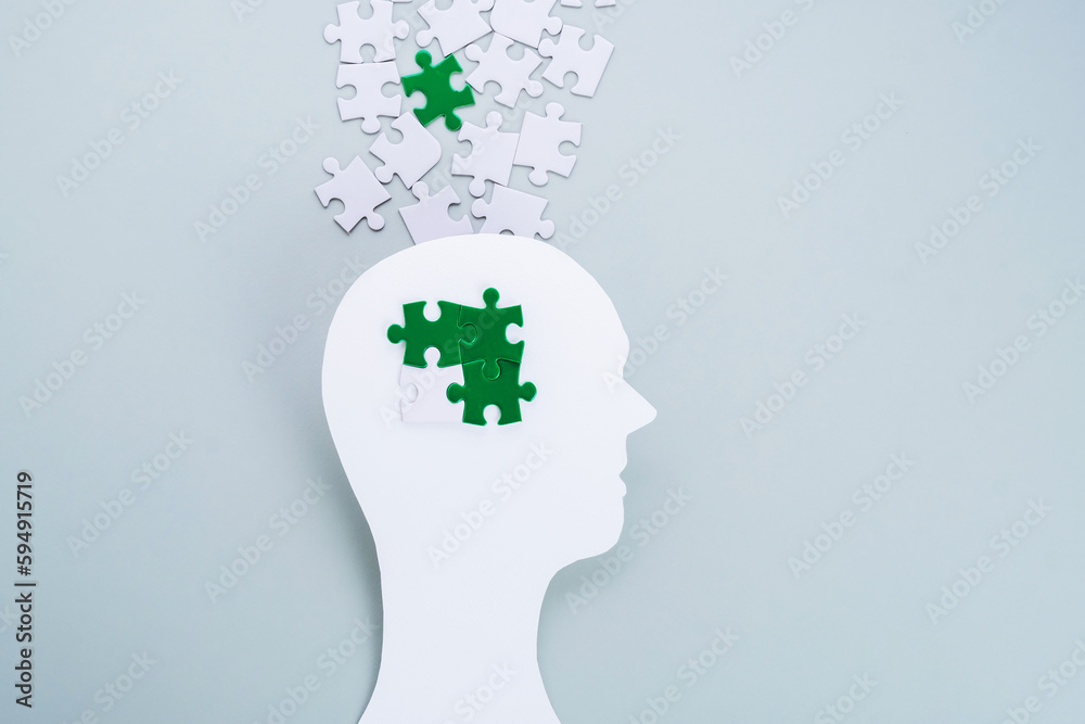 Eco-anxiety affecting mental health. Paper cutting head with green puzzles in grey background. Environmental awareness and eco education. Eco-anxiety affecting mental health. Paper cutting head with green puzzles in grey background. Environmental awareness and eco education.