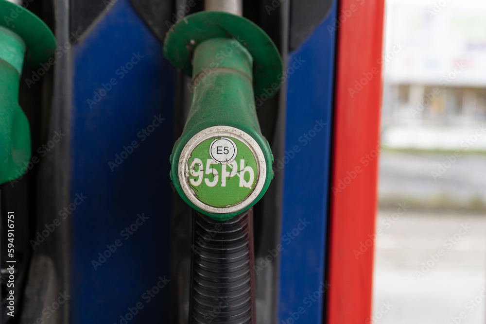Fototapeta premium Unleaded 95 gasoline. Fuel nozzle with hose, attached to the gas station column. Pb 98 E5 pump stand or dispenser machine at self-service petrol filling station.