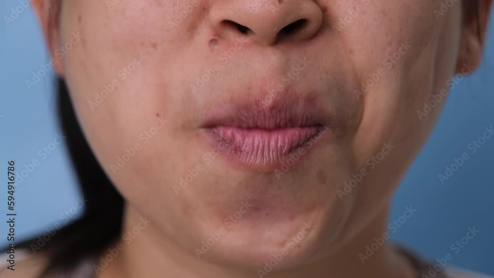 Young woman chewing gum and blowing bubble gum on blue background. Young woman chewing gum and blowing bubble gum on blue background.