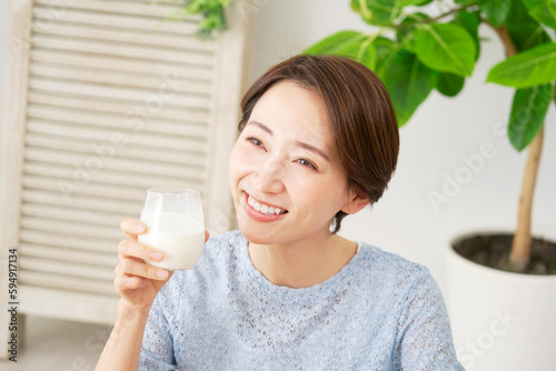 自宅で牛乳を飲む女性