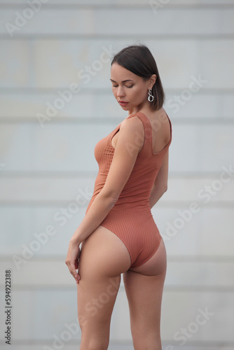 young athletic woman with beautiful figure in bodysuit