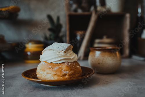 Bun with whipped cream on plate