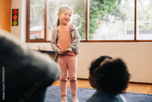 Tableau sur toile Shy little girl standing in front of her class to do an oral presentation