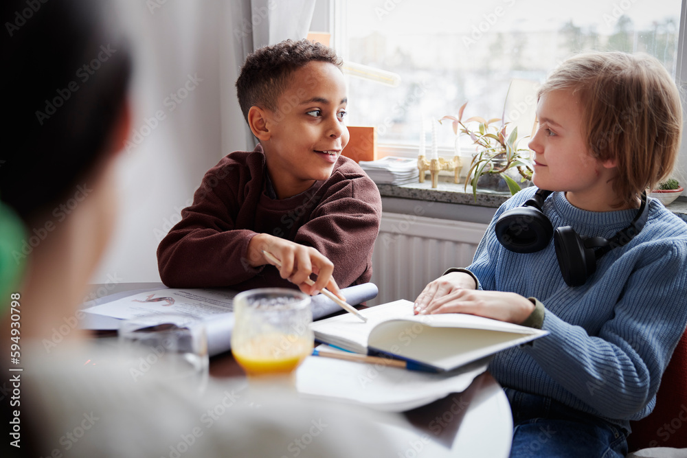 Two boys doing homework at dining table Two boys doing homework at dining table
