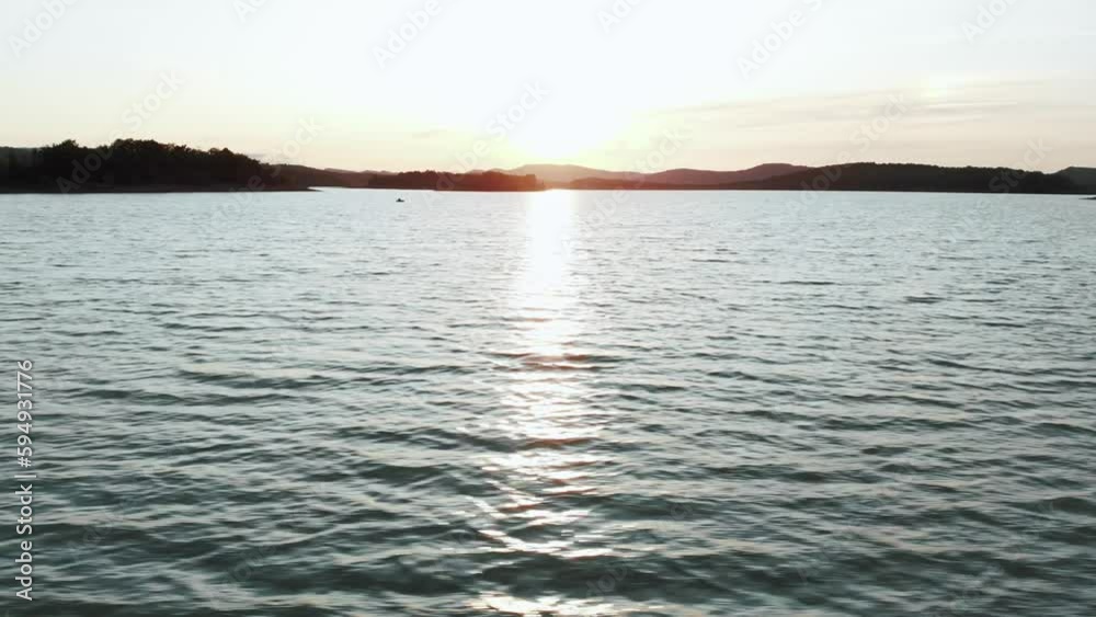 Sunset at a lake in France. Aerial tracking drone shot close to the water Sunset at a lake in France. Aerial tracking drone shot close to the water