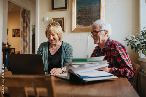 Senior couple using laptop at home