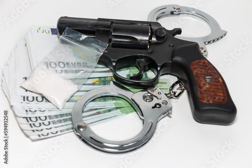 Obraz na płótnie Revolver, euro, handcuffs and a bag of white powder on a white background. The concept of punishment for the manufacture and sale of drugs. w salonie