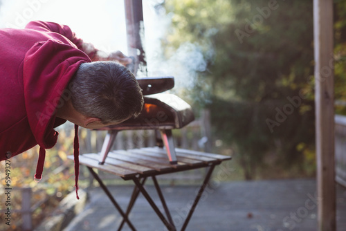 Man starting fire in outdoor pizza oven photo