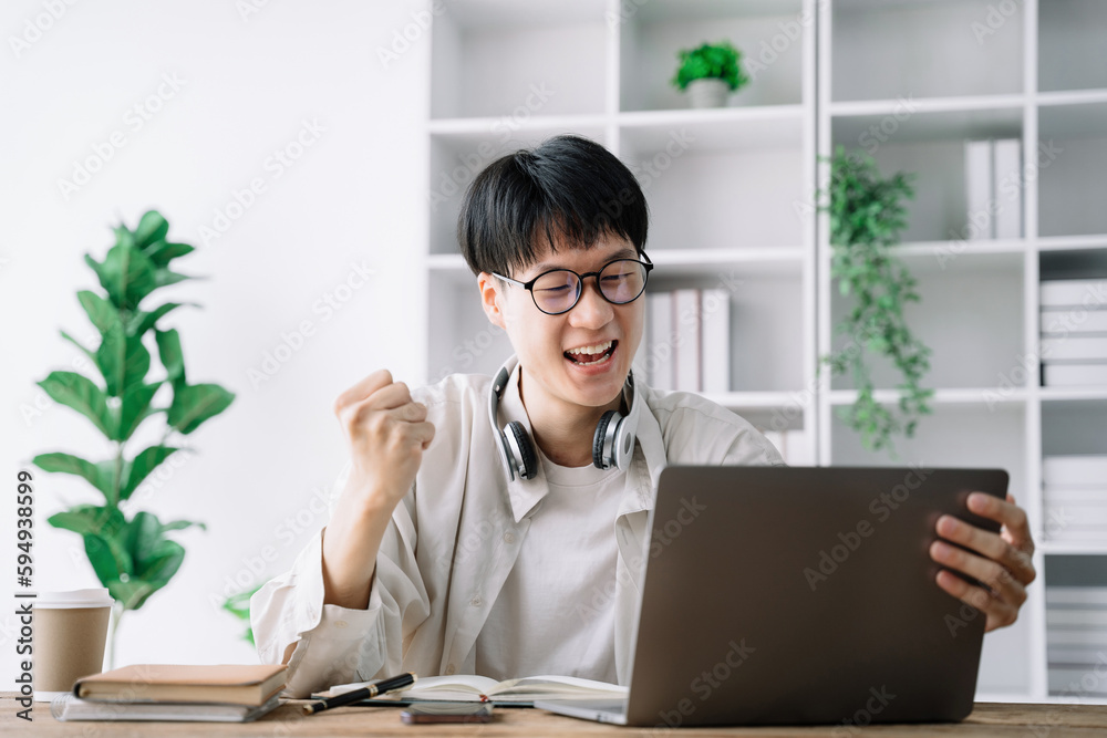 Happy student male says yes, passed an important test, raises hand with fist in excitement, smiles sincerely. Happy student male says yes, passed an important test, raises hand with fist in excitement, smiles sincerely.