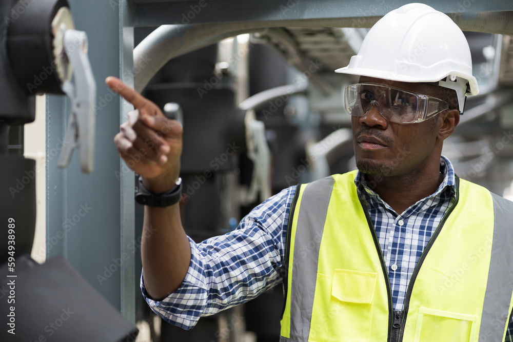 Male plumber engineer inspecting quality of work at sewer pipes area at construction site. African American male engineer worker check or maintenance sewer pipe network system at rooftop of building Male plumber engineer inspecting quality of work at sewer pipes area at construction site. African American male engineer worker check or maintenance sewer pipe network system at rooftop of building