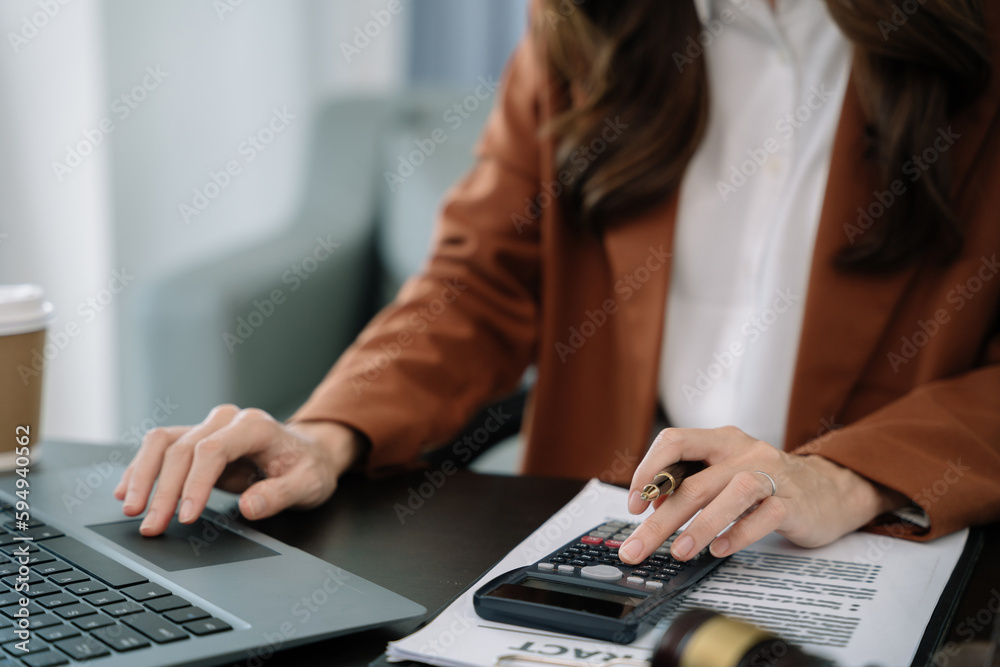 Fototapeta premium Lawyer or accounting department writes a note and uses a calculator to calculate expenses - income. at office lawyer.