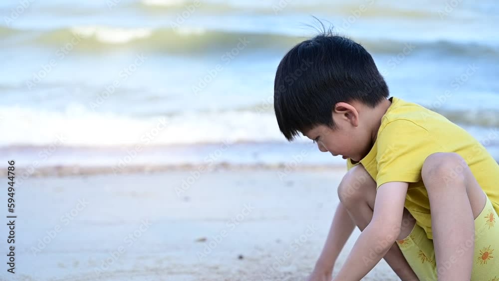 asia lovely boy is playing and writing in sand on the beach, slow motion scene asia lovely boy is playing and writing in sand on the beach, slow motion scene
