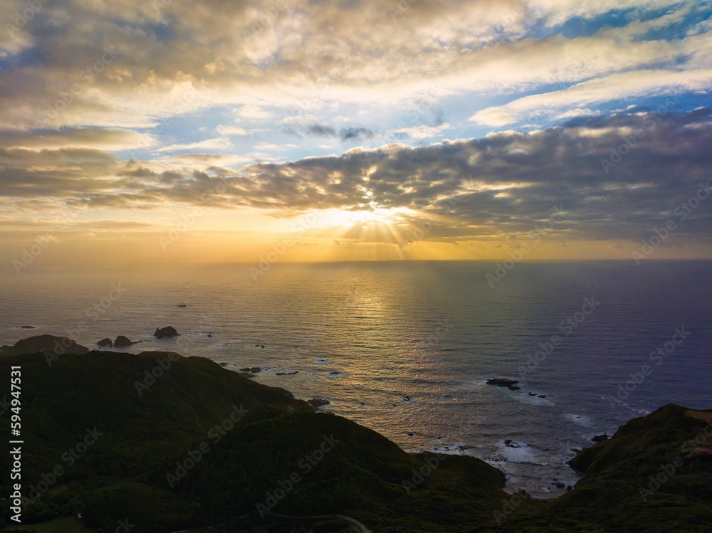 Aerial view of a beautiful bright sunset sky over the Pacific Ocean shore