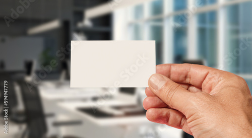 Ręka trzymająca wizytówkę na tle biura