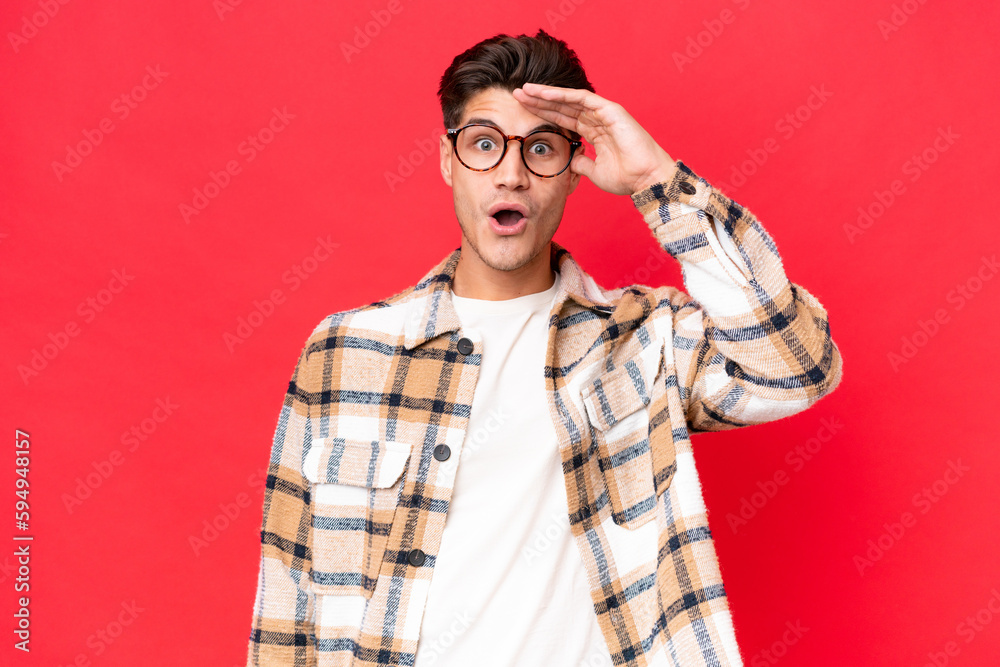 Young caucasian handsome man isolated on red background has realized something and intending the solution