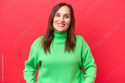 Middle-aged caucasian woman isolated on red background laughing