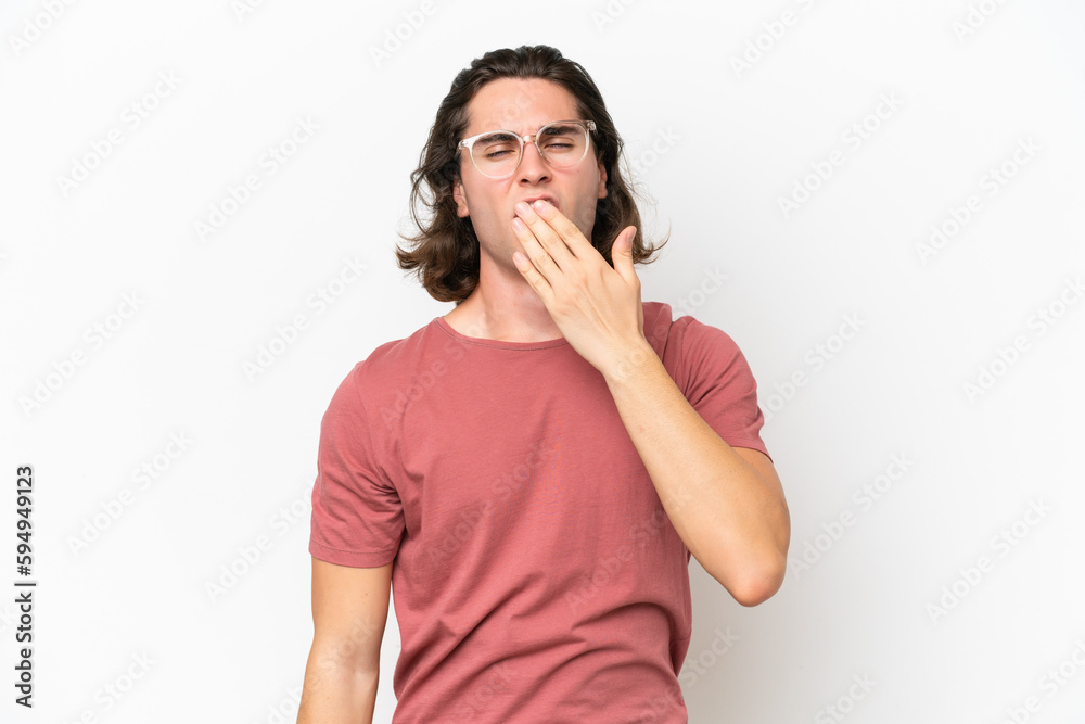 Young handsome man isolated on white background yawning and covering wide open mouth with hand Young handsome man isolated on white background yawning and covering wide open mouth with hand