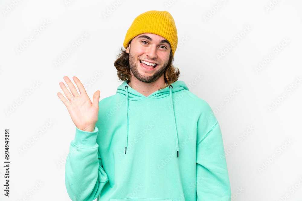 Young handsome man isolated on white chroma background saluting with hand with happy expression