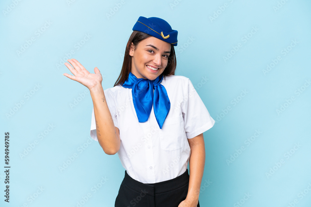 Airplane stewardess caucasian woman isolated on blue background saluting with hand with happy expression Airplane stewardess caucasian woman isolated on blue background saluting with hand with happy expression