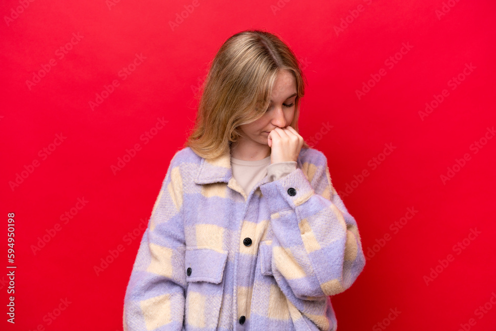 Young English woman isolated on red background having doubts