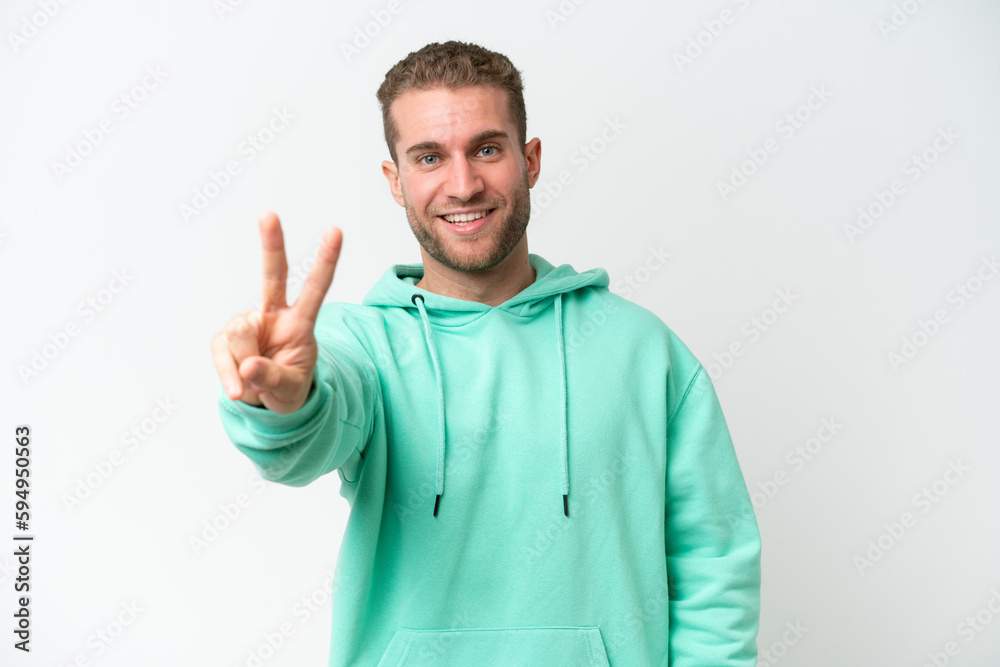 Young handsome caucasian man isolated on white background smiling and showing victory sign
