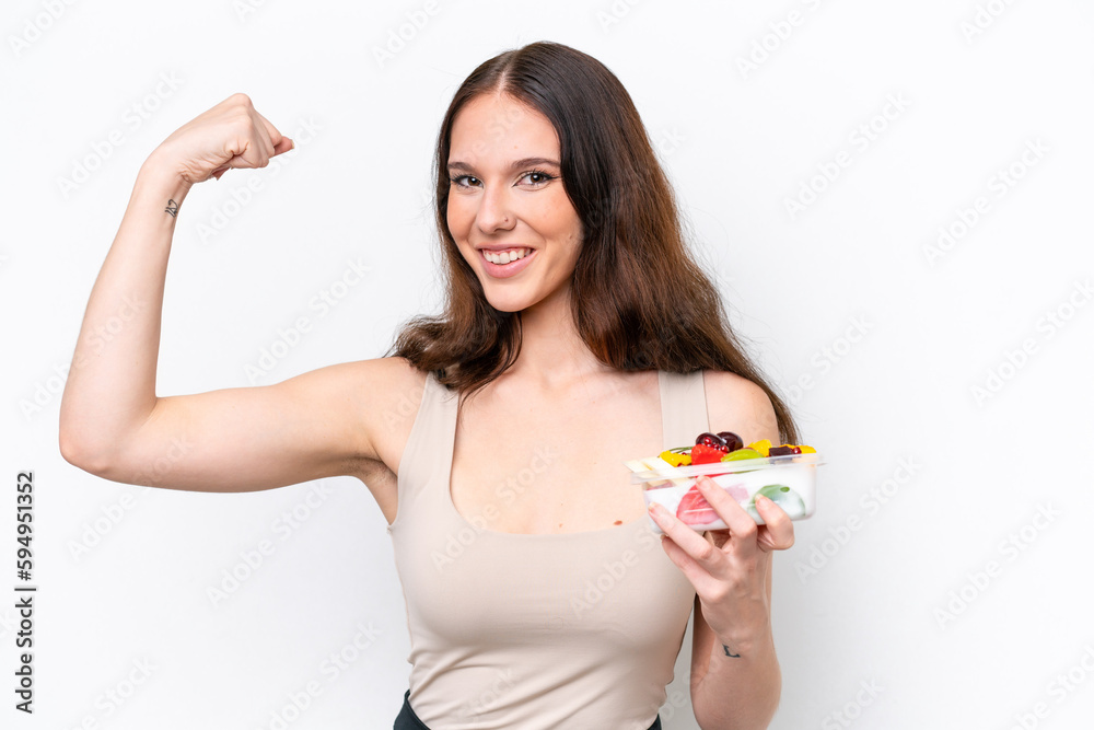 Young caucasian woman holding a bowl of fruit isolated on white background doing strong gesture Young caucasian woman holding a bowl of fruit isolated on white background doing strong gesture