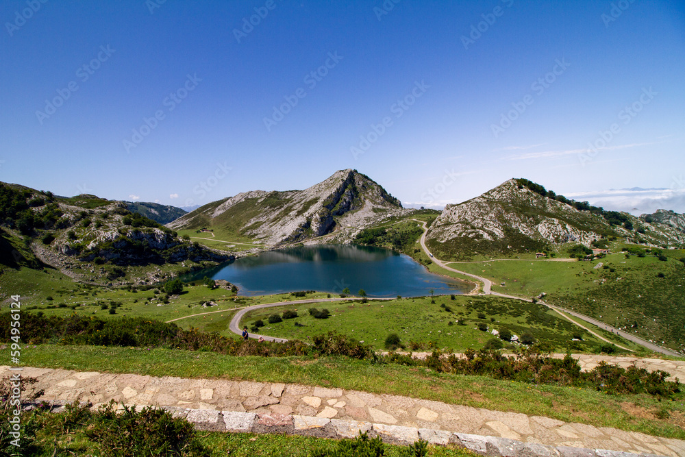 Lake Covadonga, in the mountains of Asturias, with green grass and blue summer sky.