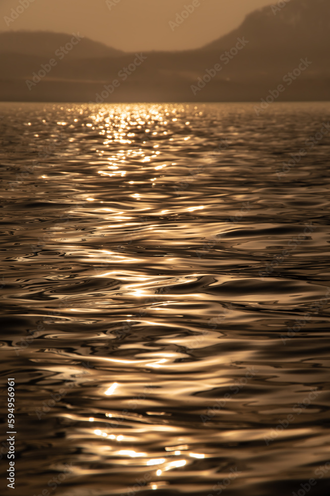 太陽の光を滑らかに反射する水面の波