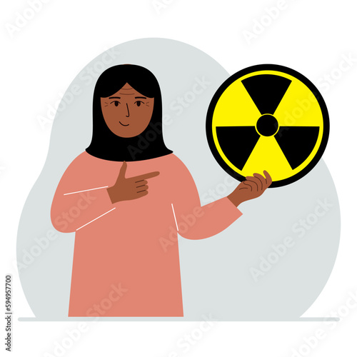 A woman holds a sign with a warning about nuclear danger. The concept of nuclear war, radiation, biohazard.