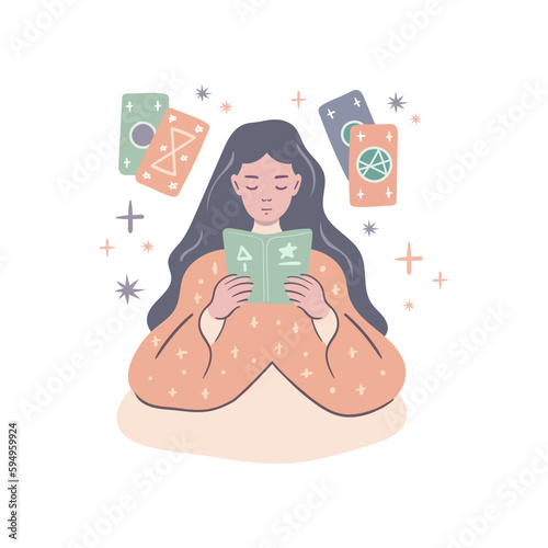 Young girl is reading a book about magic and tarot cards