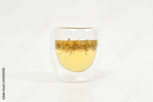 Chamomile tea at double wall glass white chamomile buds. herbal tea. 