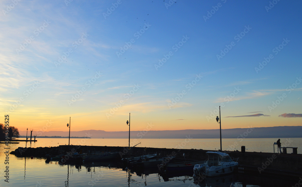 Lake Geneva at sunset, wooden pier on big lake in Evian