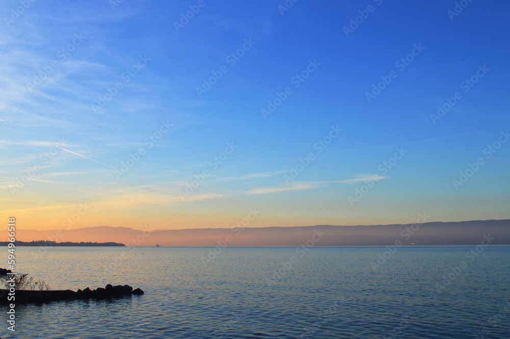 Sunset on the lake, calm water. Lake Geneva at sunset, Evian, France