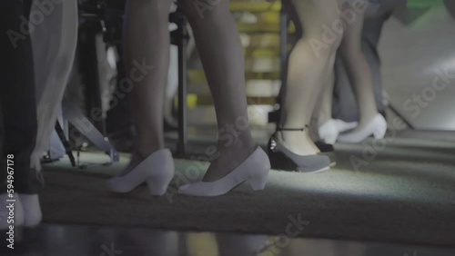 A closeup shot of dancing feet on the stage. They're wearing white and black shoes while tap dancing. photo