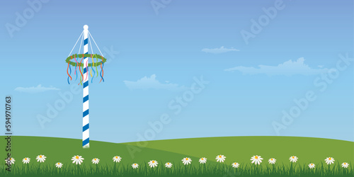 maypole with colorful ribbons on green meadow