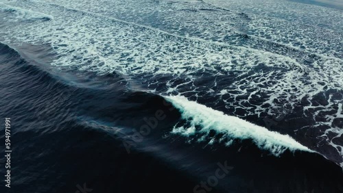 Waves on black beach in front of beautiful Icelandic coastline